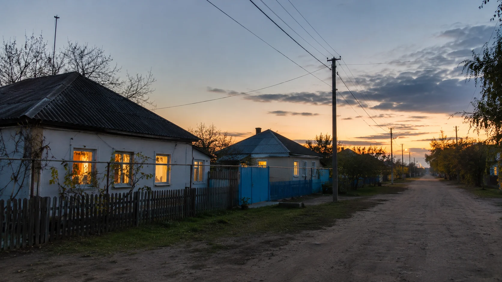 Сельская улица Нижнедолговского поселения вечером с тёплым светом в окнах